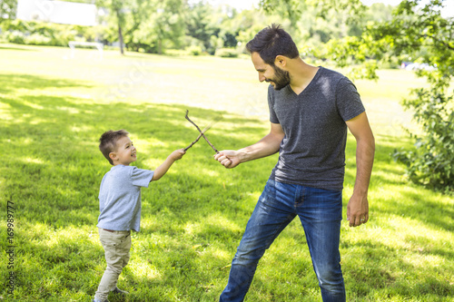 Father and son playing on the meadow.