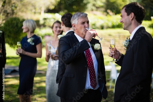 Guests having champagne while attending wedding