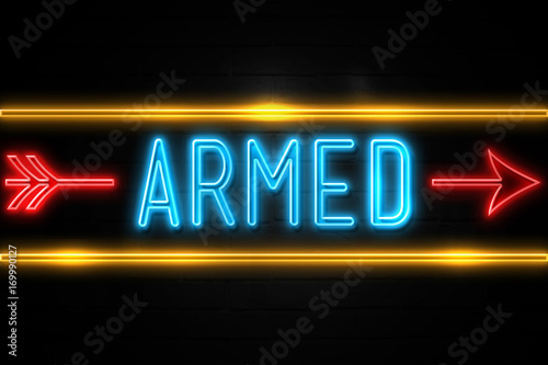 Armed - fluorescent Neon Sign on brickwall Front view