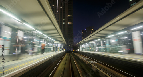 A railway track and a train station seen through a long exposure motion blur in London, England, UK during early evening