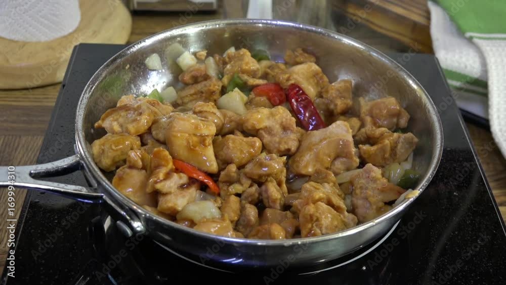 Kung Pao Chicken simmering in a stainless steel frying pan Kung Pao Chicken simmering in a stainless steel frying pan