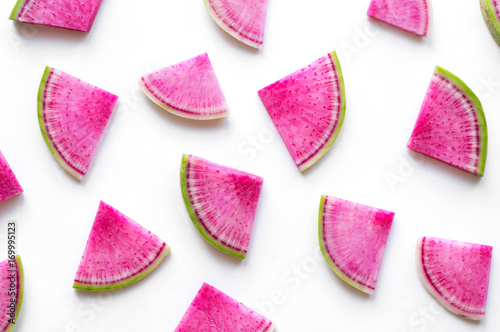 Isolated watermelon radish slices. Colorful pink pieces on white background.