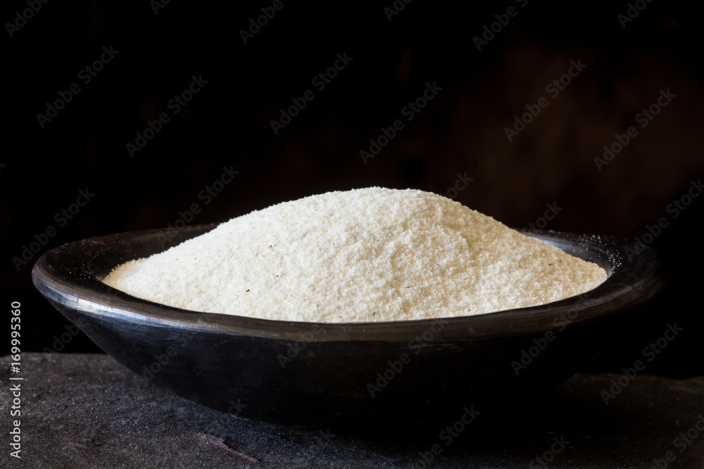 Maize flour (Zea mays) in a traditional black clay dish Maize flour (Zea mays) in a traditional black clay dish
