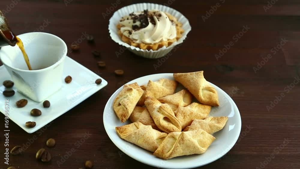 On the table are coffee beans and biscuits. Black coffee is poured into the white cup. Full hd shot with dolly from right to left On the table are coffee beans and biscuits. Black coffee is poured into the white cup. Full hd shot with dolly from right to left