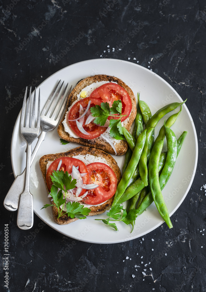 Tomato and cheese sandwiches and green beans - healthy vegetarian snack on a dark table, top view Tomato and cheese sandwiches and green beans - healthy vegetarian snack on a dark table, top view