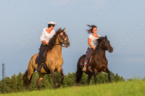 two women ride Andalusian horses