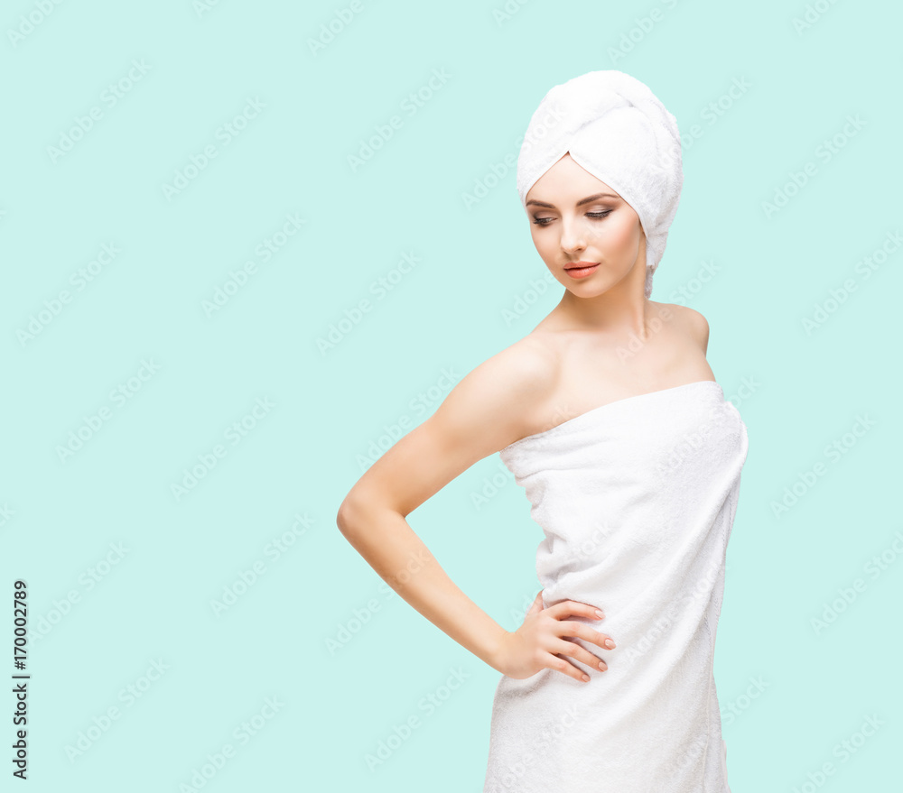 Young, beautiful and natural woman wrapped in towel over cyan background. Young, beautiful and natural woman wrapped in towel over cyan background.