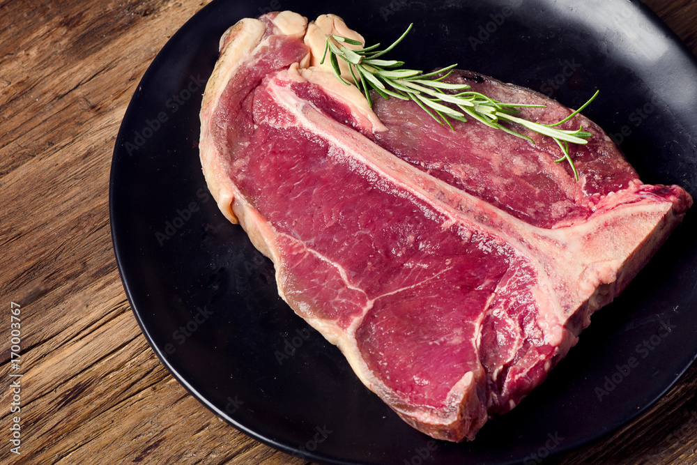 Dry aged t-bone steak on a dark wooden background. Dry aged t-bone steak on a dark wooden background.