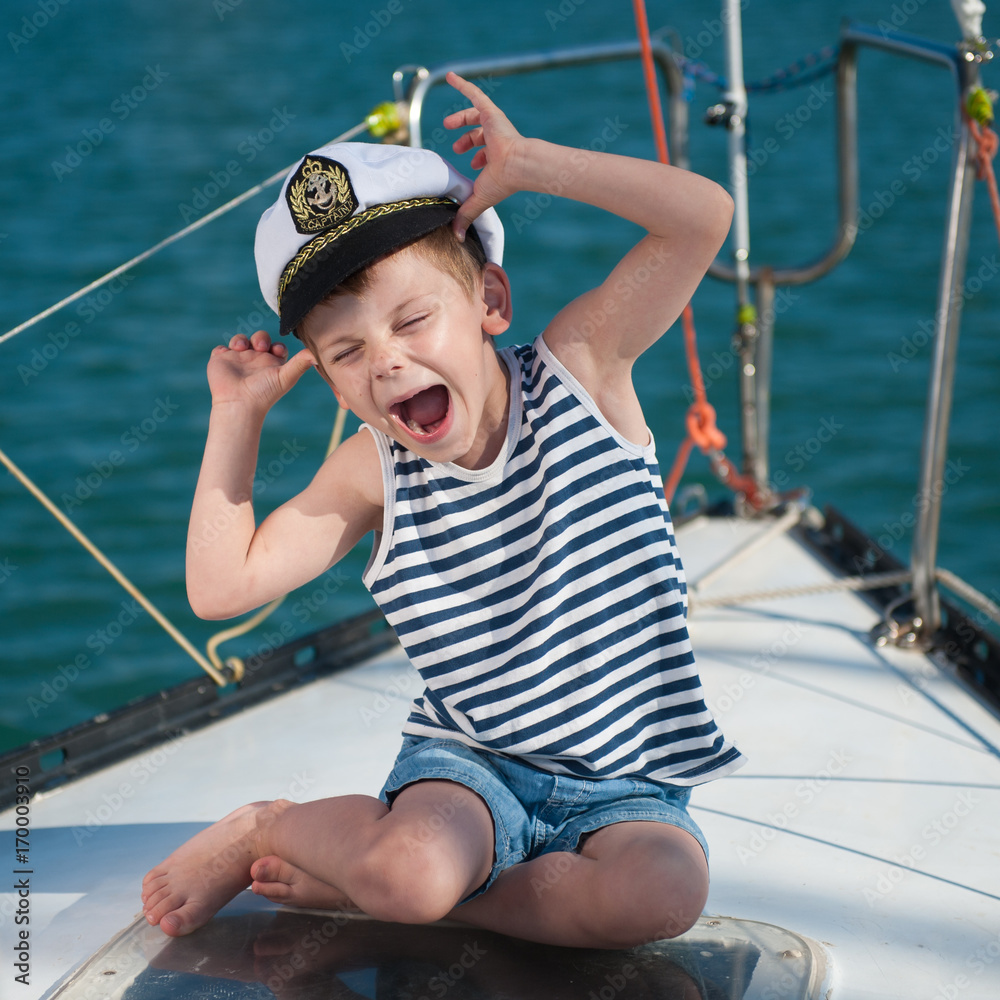 funny little boy wearing captain hat sitting aboard luxury boat Stock Photo  | Adobe Stock