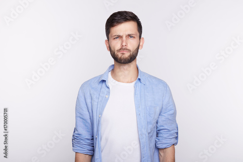 Human facial expressions, emotions and feelings. Studio shot of disgusted young blue eyed Caucasian man dressed casually, grimacing, looking in terror and disgust, feeling averse to do something. © Yulia