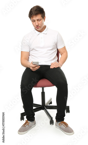 Cute teenage boy with mobile phone on white background