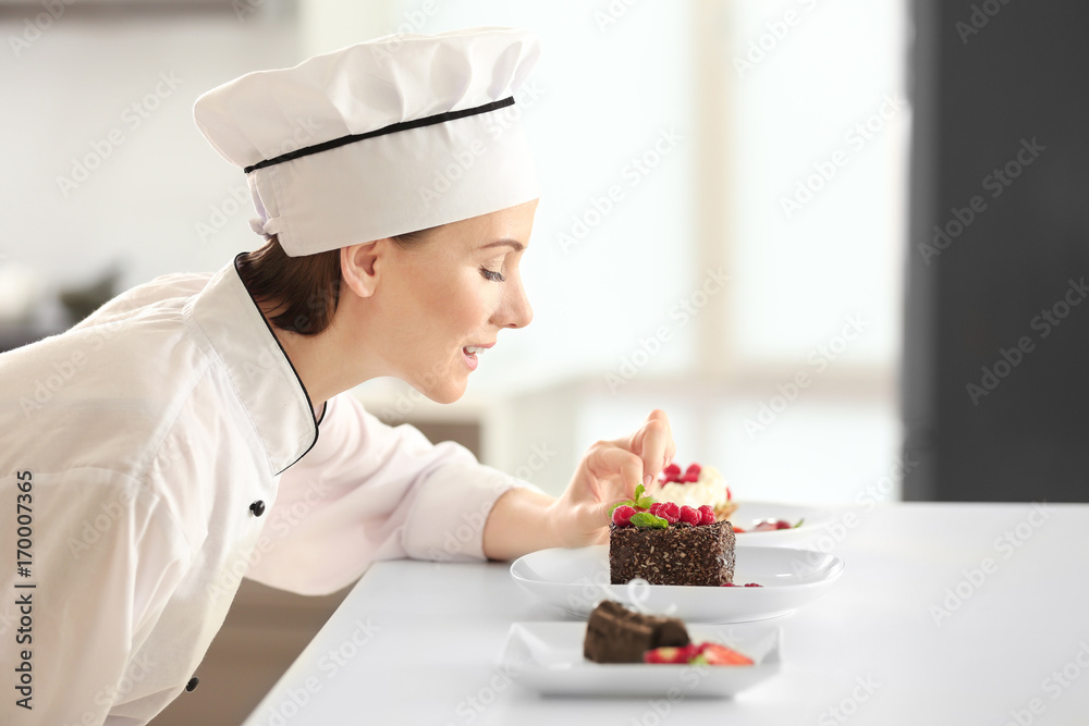 Female chef decorating tasty desserts in kitchen Female chef decorating tasty desserts in kitchen