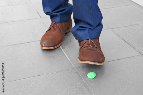 Man and chewing gum on sidewalk. Concept of stickiness