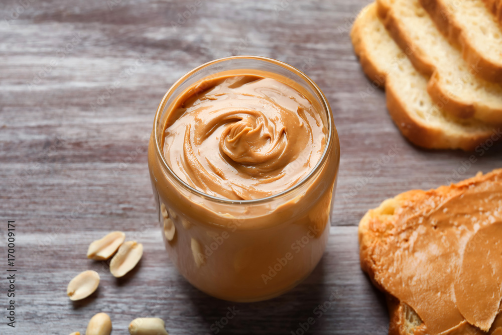 Jar with creamy peanut butter on table Jar with creamy peanut butter on table