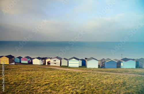 Blue sky and colorful beach huts along the coastline of Whitstable - retro styled photo © erika8213