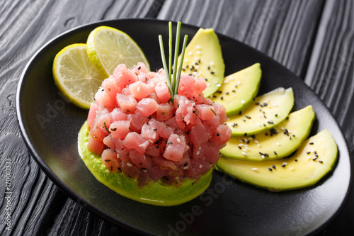 tartar of fresh tuna with spices, lime and sesame close-up on a plate. horizontal