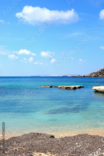 View of Ghaja Tehheiha Bay with a pebble beach in the foreground, Malta.