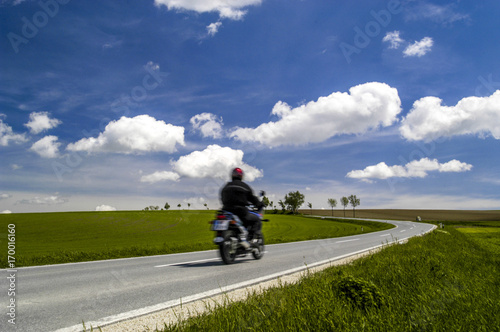 Kurvige Strasse, Allee, Felder, tiefhängende, weisse Wolken am