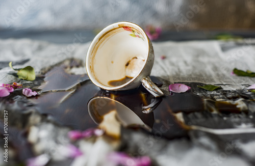 spilled coffee on the table, overturned cup of coffee