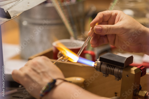 Cesky Krumlov, Czech Republic - August 17, 2017: craftsman works a glass object with a flame in the historic city center