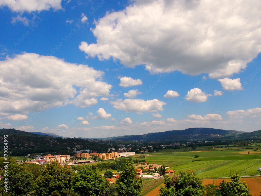 sky with big clouds on cultivated countryside and country on one side sky with big clouds on cultivated countryside and country on one side