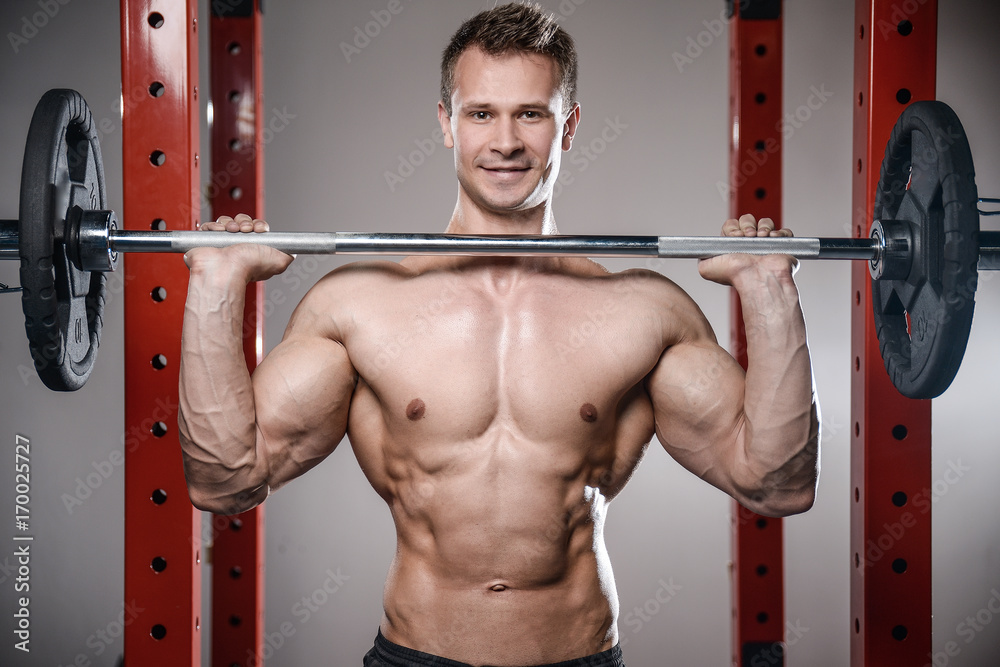 Caucasian handsome fitness model training in the gym. Man on diet flexing muscles Caucasian handsome fitness model training in the gym. Man on diet flexing muscles
