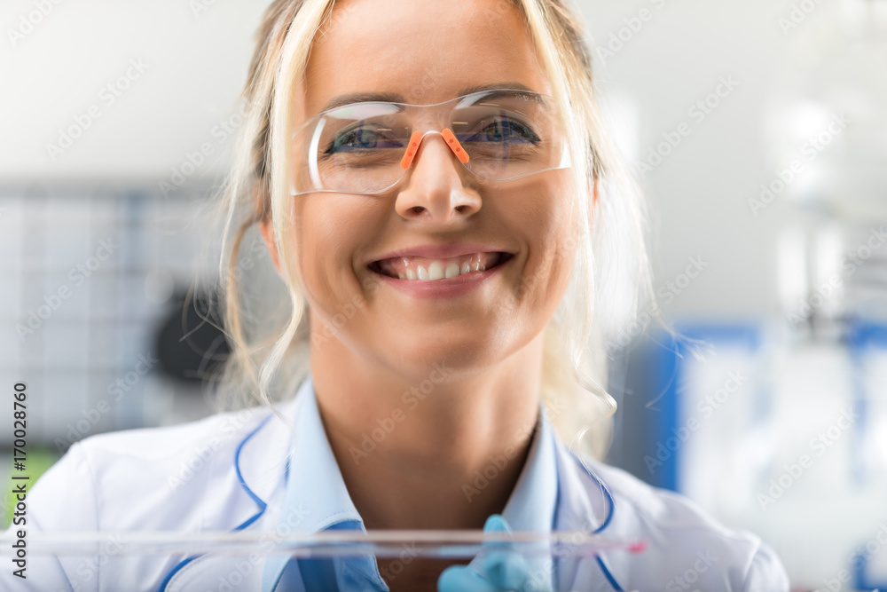 Happy young attractive smiling woman scientist in the laboratory Happy young attractive smiling woman scientist in the laboratory