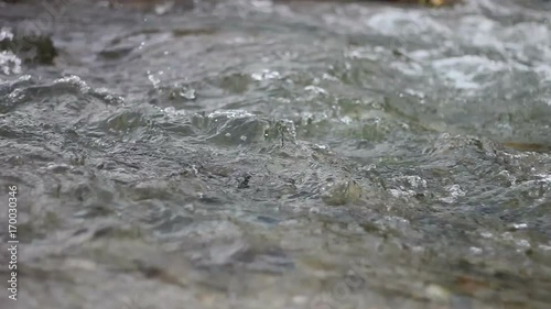 close up shot of the sacred River Ganges flowing past rocks at the holy town of Rishikesh in North India. photo