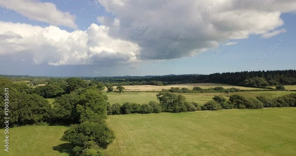 Slowly panning over the beautiful English countryside with a summer storm building in the background Slowly panning over the beautiful English countryside with a summer storm building in the background