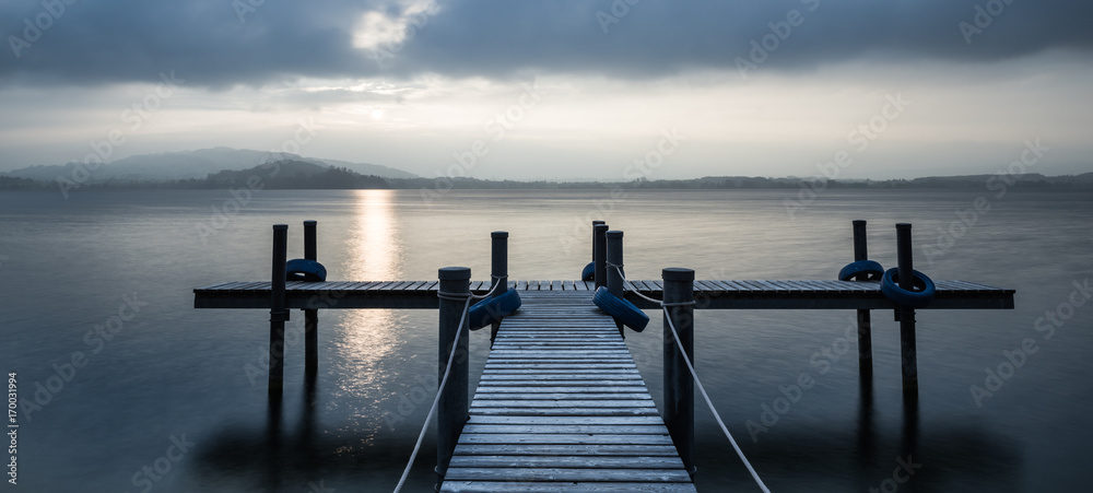 Naklejka premium Overcast. Pier. Sunset on the lake.