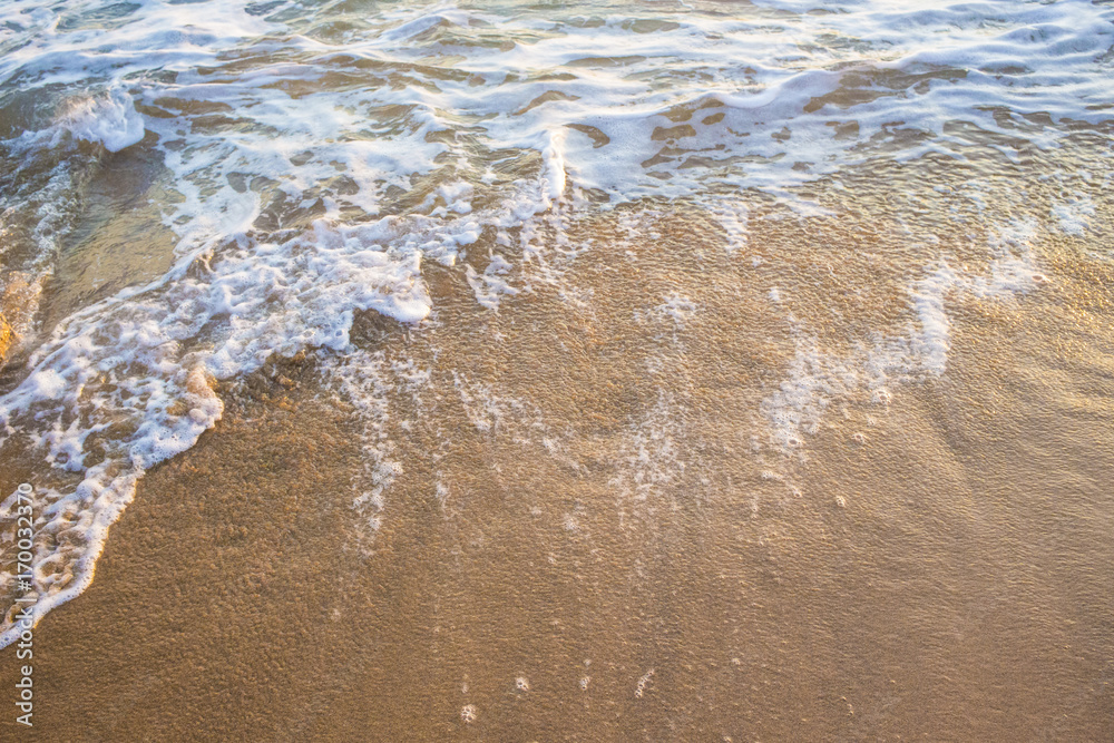 Dettaglio delle onde del mare che si infrangono sulla spiaggia. L' acqua al  contatto con la sabbia gialla forma la schiuma bianca. Stock Photo | Adobe  Stock