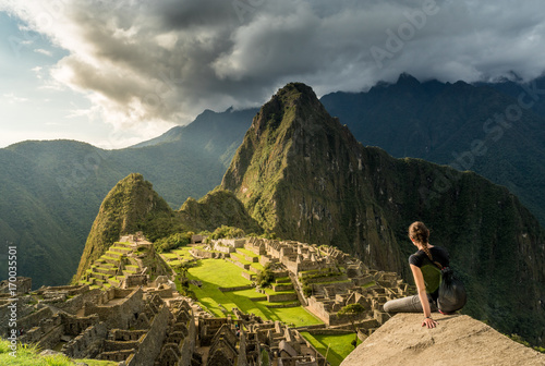 Frau geniesst Blick über die Ruinen von Machu Picchu