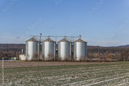 four silver reflecting silos photo