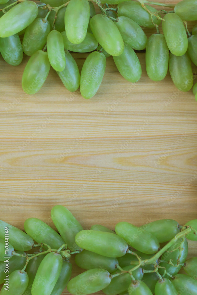 Frame of green grapes on wooden background. Copy space Frame of green grapes on wooden background. Copy space