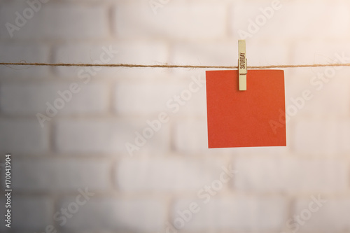 Wooden clothespin and blank paper on a rope against white brick wall,SATURDAY letters photo