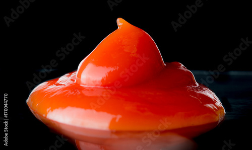 Ketchup or tomato sauce over dark background