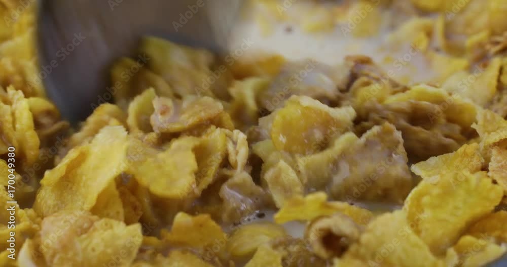 A very close view of multigrain breakfast cereal with skim milk being stirred then one bite taken with a spoon.. A very close view of multigrain breakfast cereal with skim milk being stirred then one bite taken with a spoon..