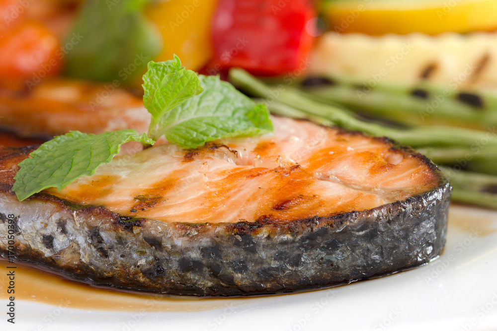 Salmon grill on teriyaki sauce and vegetable grill in white dish on the wooden table Salmon grill on teriyaki sauce and vegetable grill in white dish on the wooden table