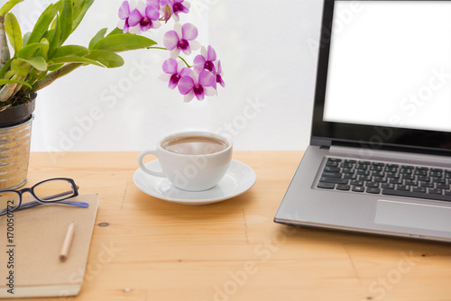 Minimal workspace,computer laptop,coffee cup,orchid flower and notebook on wooden table over white background