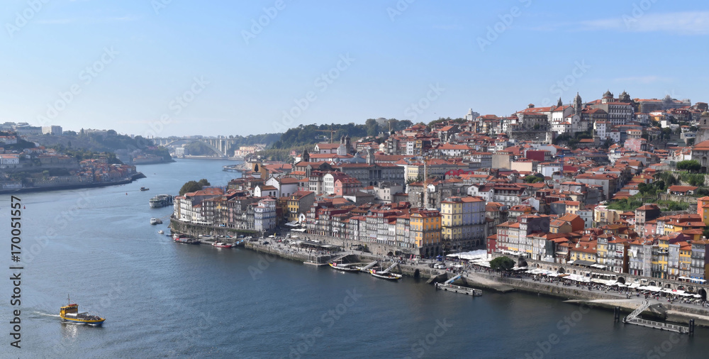 Boat navigates Duoro River in View of Historic Porto, Portugal