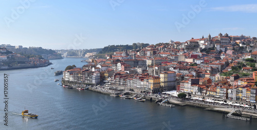 Boat navigates Duoro River in View of Historic Porto, Portugal