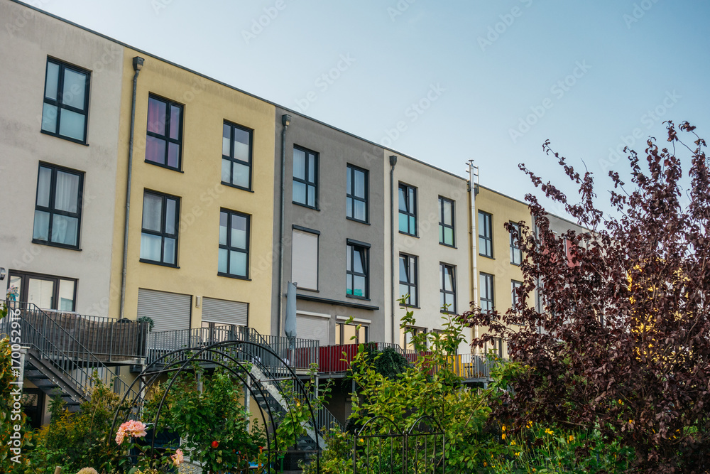 some colorful modern row houses with bushes and trees