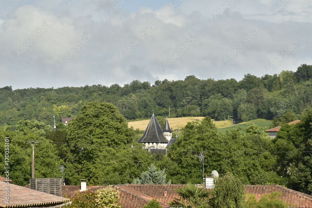 Les tourelles du château entre les arbres à Champagne au Périgord Vert