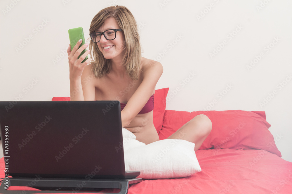 Cute girl holding cellphone in the bed. Cute girl holding cellphone in the bed.