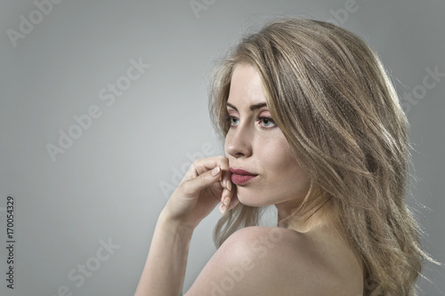 Attractive blonde woman on dark background .