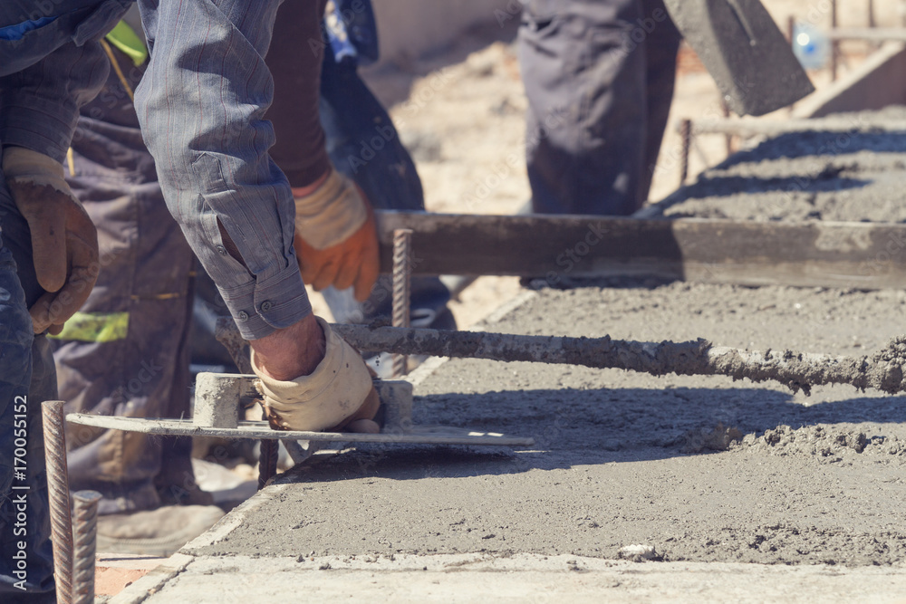 Construction worker leveling concrete pavement outdoors. Construction worker leveling concrete pavement outdoors.