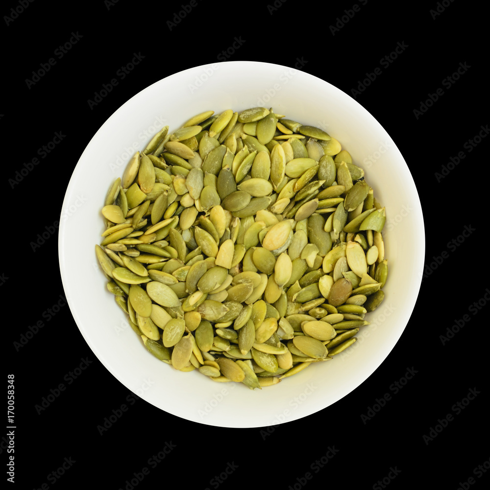 Pumpkin seeds in a bowl isolated on black Pumpkin seeds in a bowl isolated on black