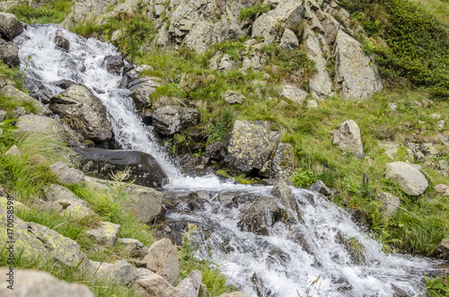 stream of water, view of a small river on the mountain alps