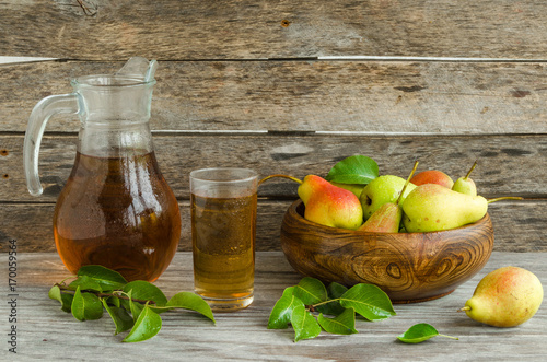 Pears in a wooden dish and a carafe of pear juice