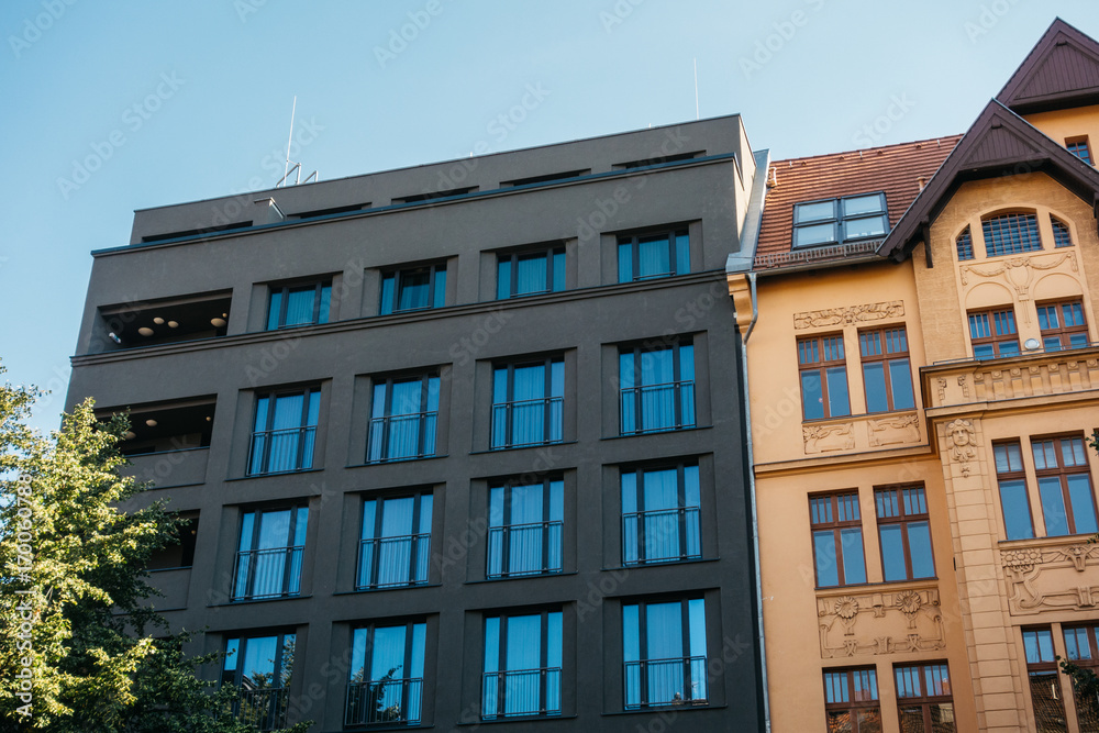 darken grey facaded building next to orange one